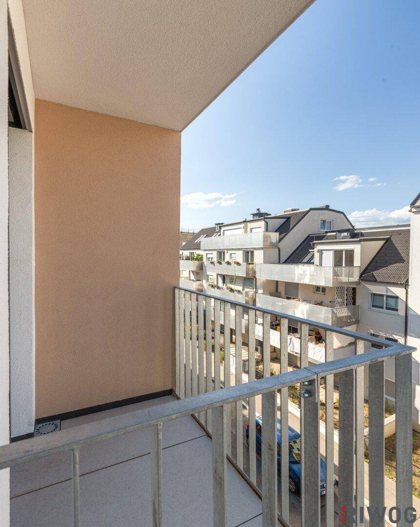 Heller Balkon mit Metallgeländer und Blick auf die umliegenden Gebäude.