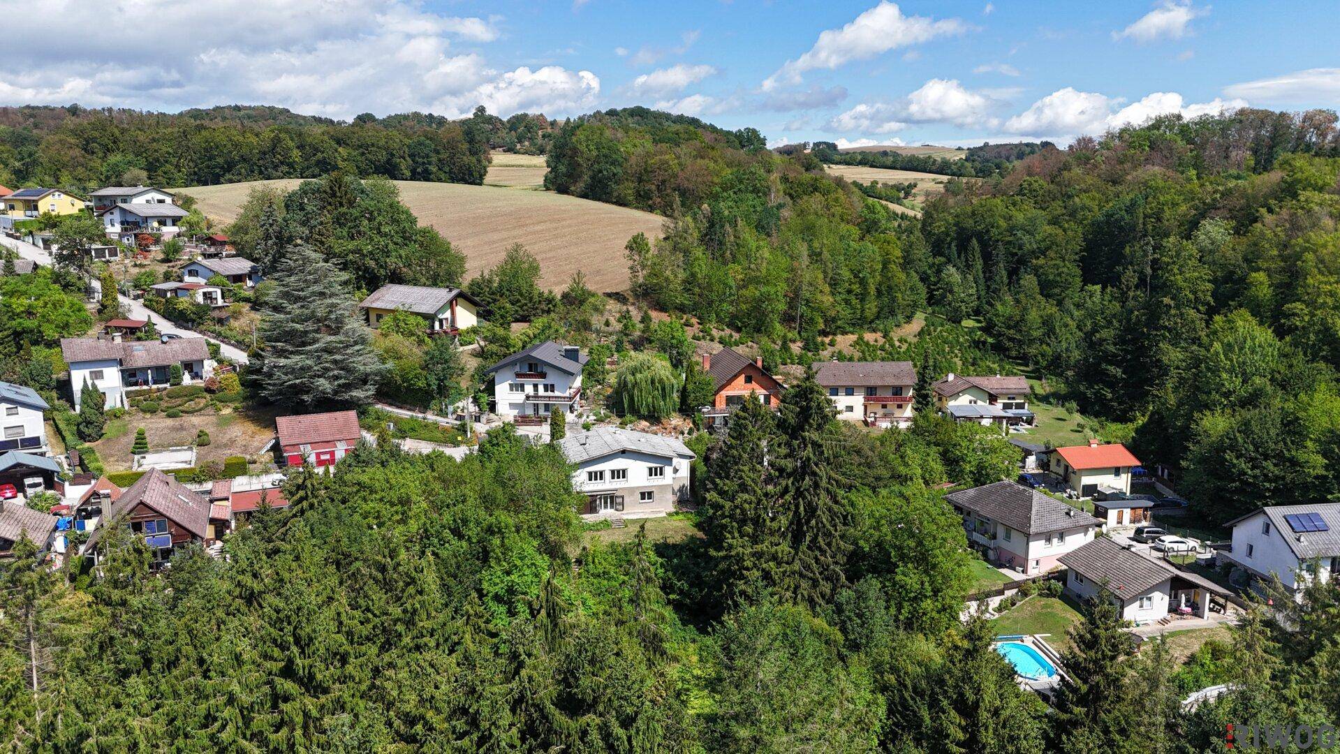 Luftaufnahme einer Wohngegend mit Feldern und Wäldern, die eine weite Aussicht bieten.