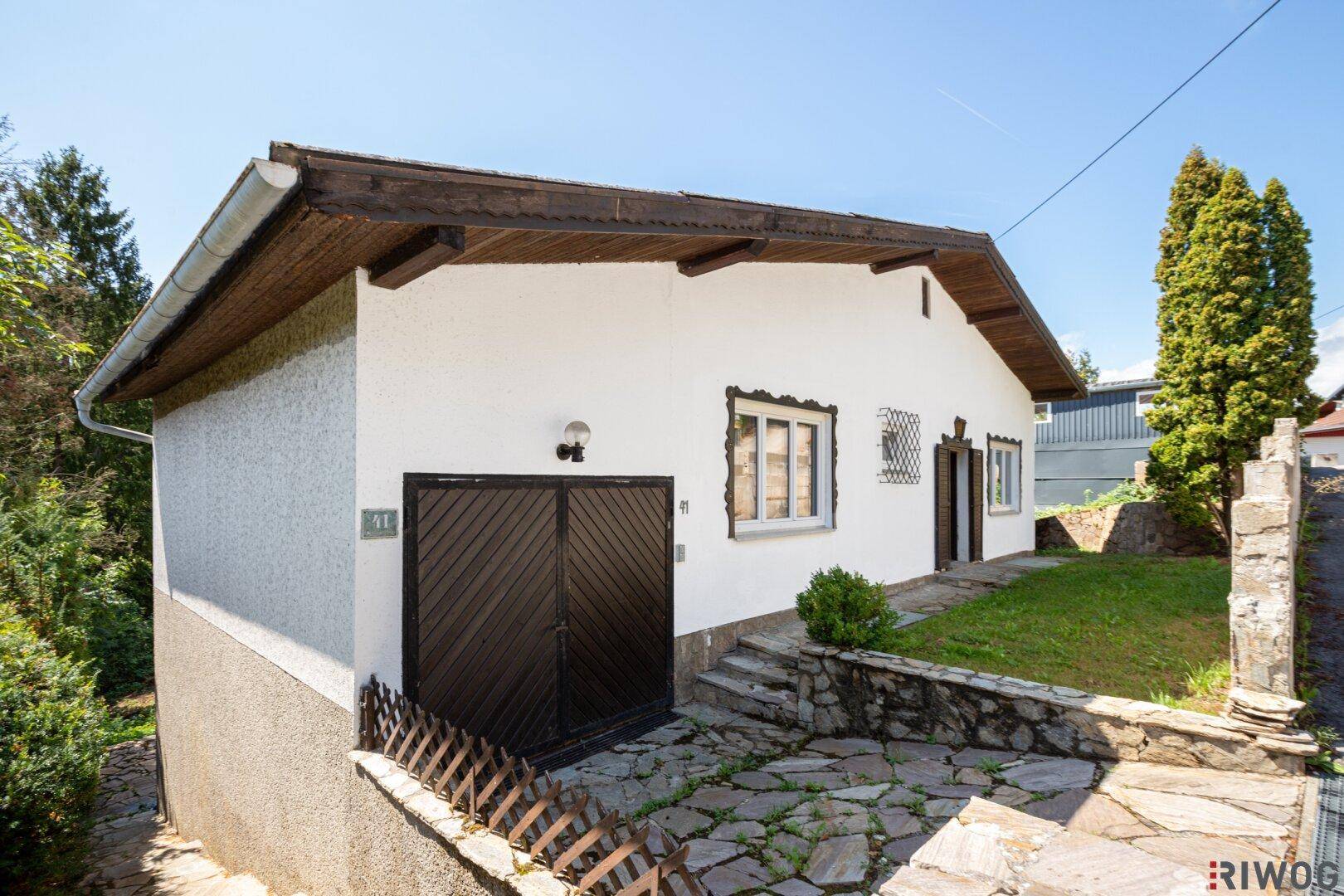 Vorderansicht des Hauses mit integrierter Garage und traditionellem Satteldach.