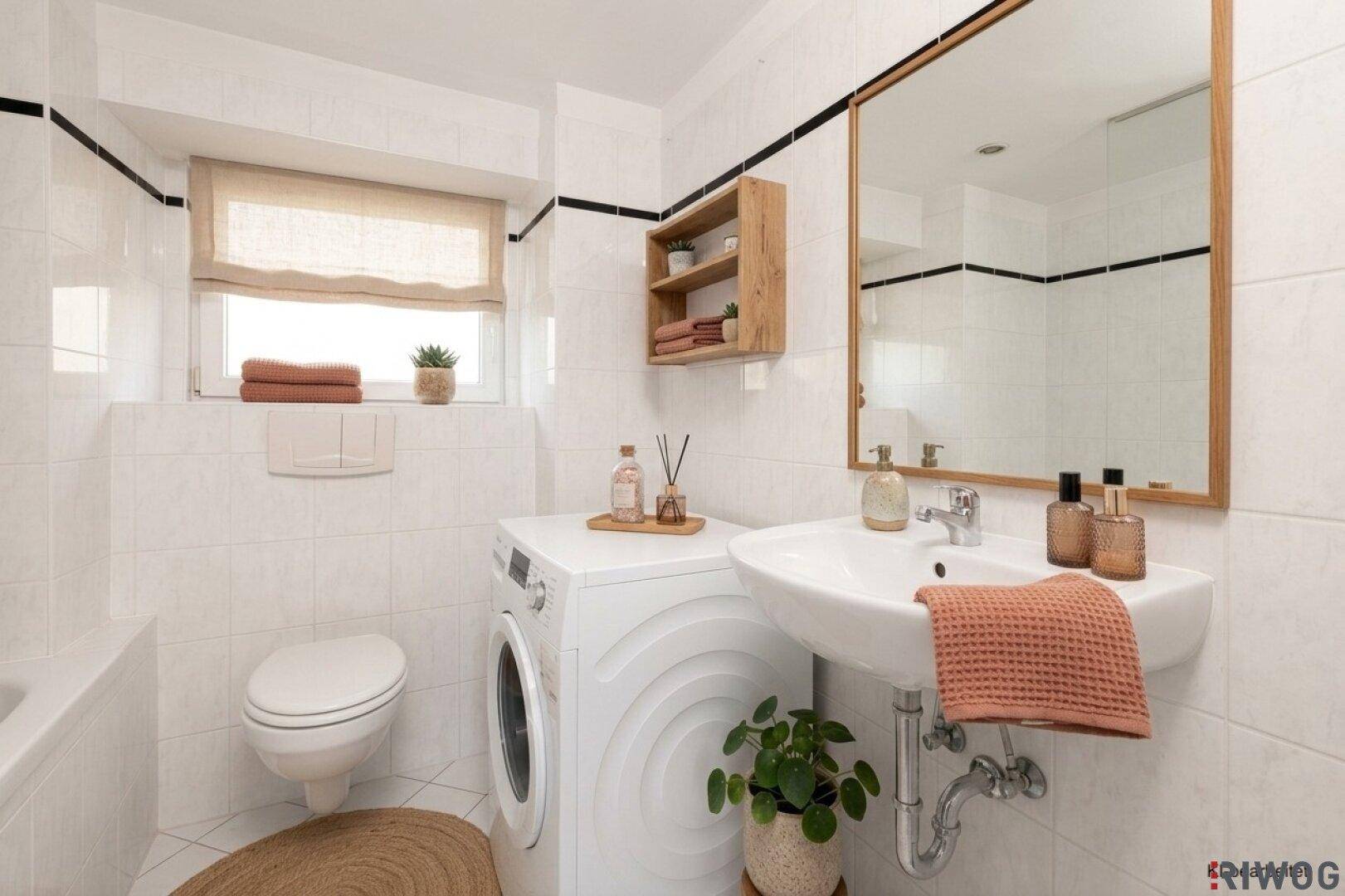 Modernisiertes Badezimmer mit weißen Fliesen, Waschmaschine, Waschbecken und Dekoration.