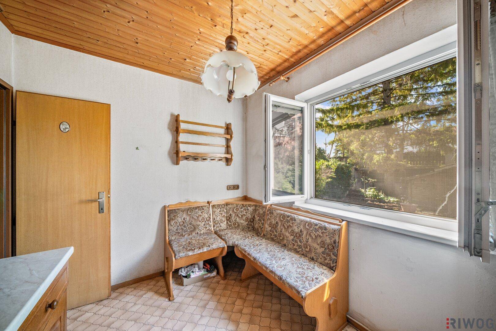 Detailansicht des Essbereichs in der Küche mit Eckbank und Holzdecke.