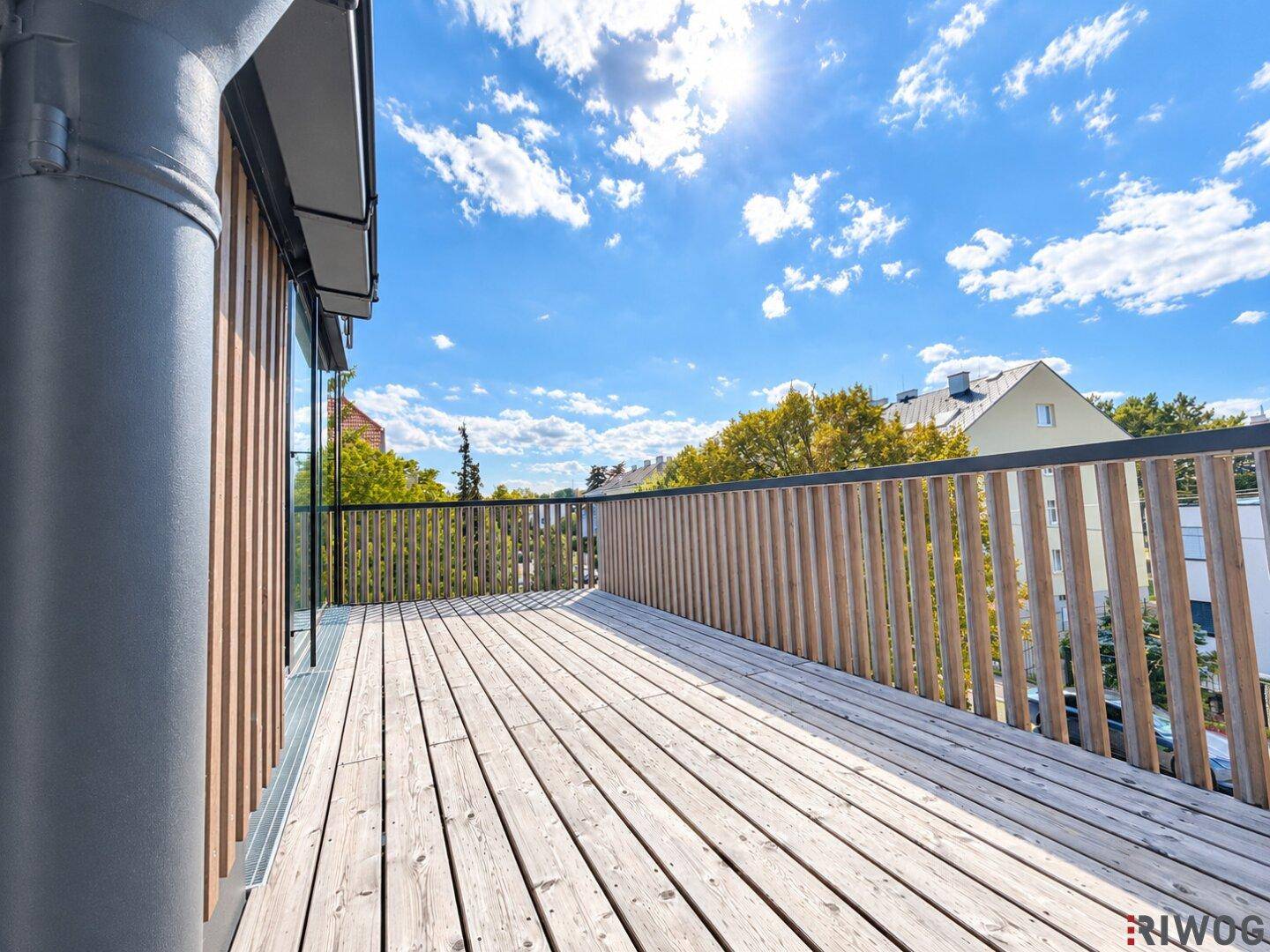 Geräumige Holzterrasse mit modernem Geländer, ideal für entspannte Stunden im Freien.