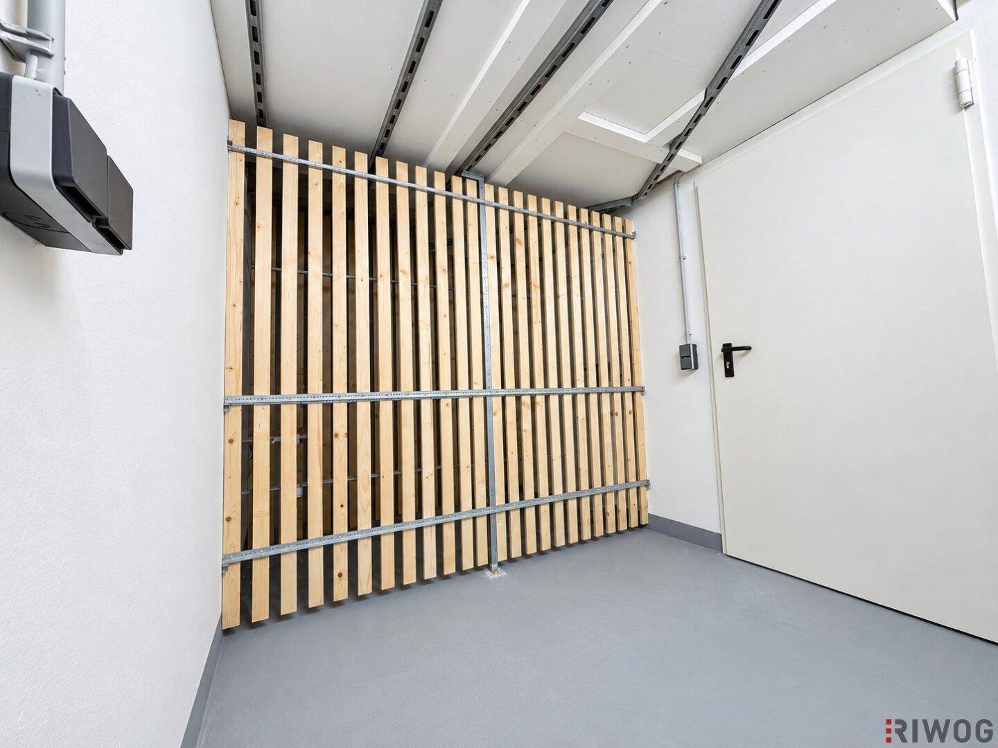 Praktischer Abstellraum mit Holzlattenabtrennung, ideal für zusätzlichen Stauraum im Kellerbereich.