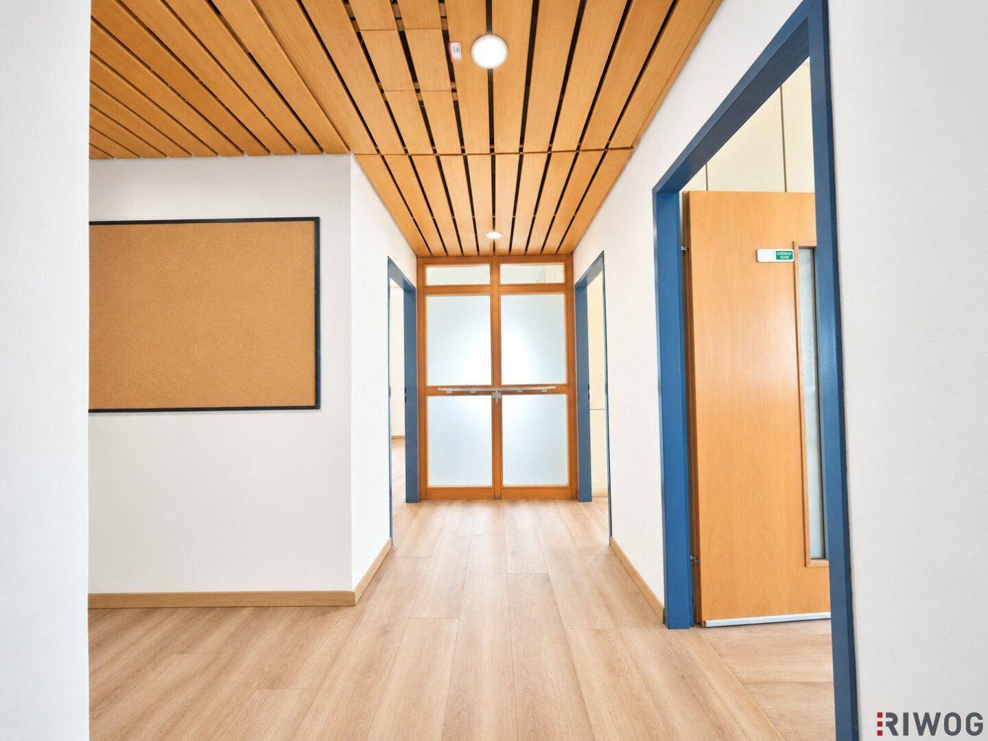 Heller Flur mit Holzlattendecke, Laminatboden und mehreren Türen, die zu verschiedenen Räumen führen.