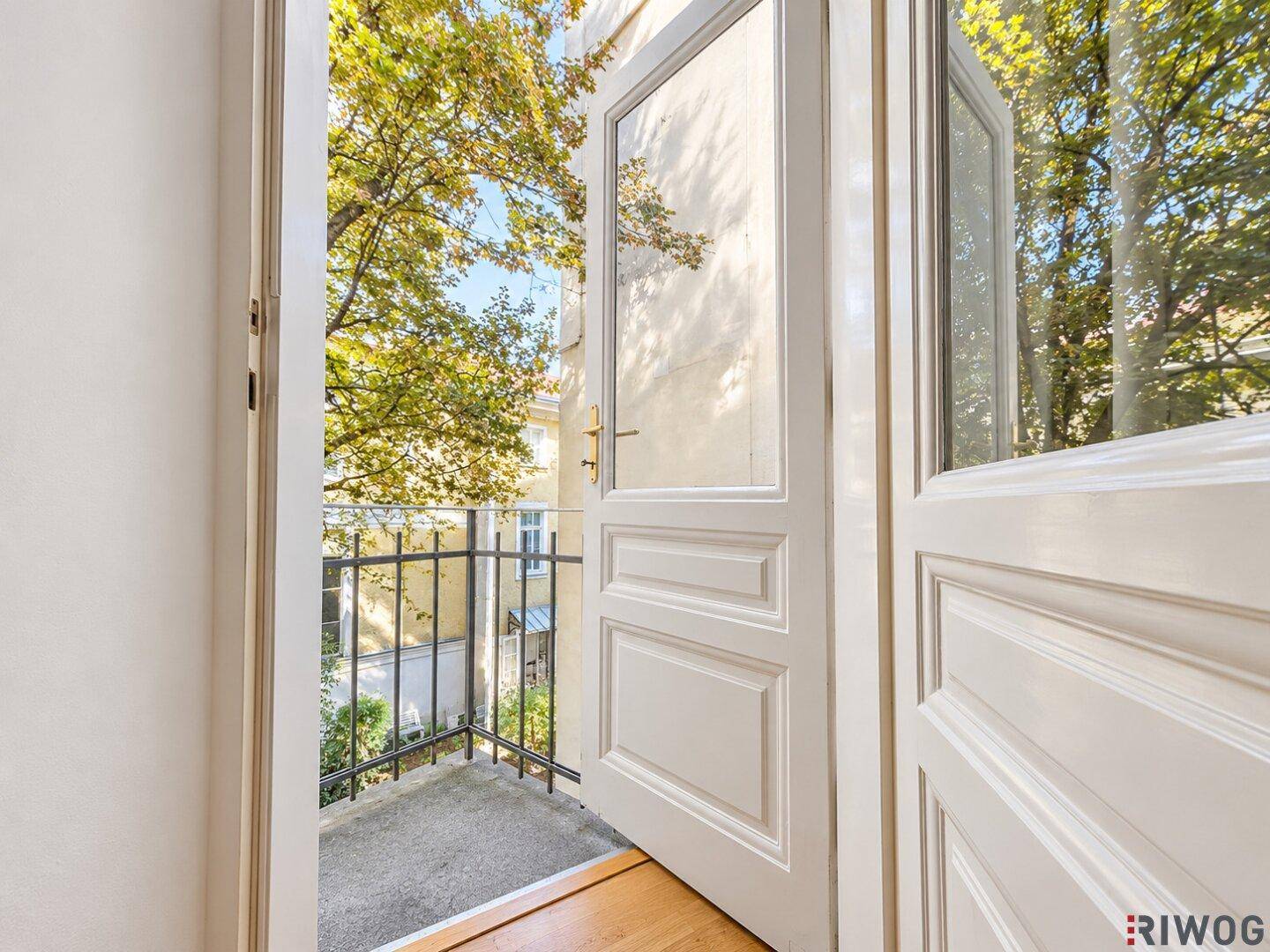 Zugang zum kleinen Balkon mit Blick auf den begrünten Innenhof.