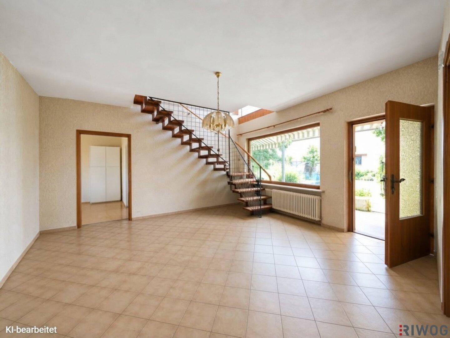 Helles Wohnzimmer mit gefliestem Boden, offener Treppe und Zugang zum Gartenbereich.