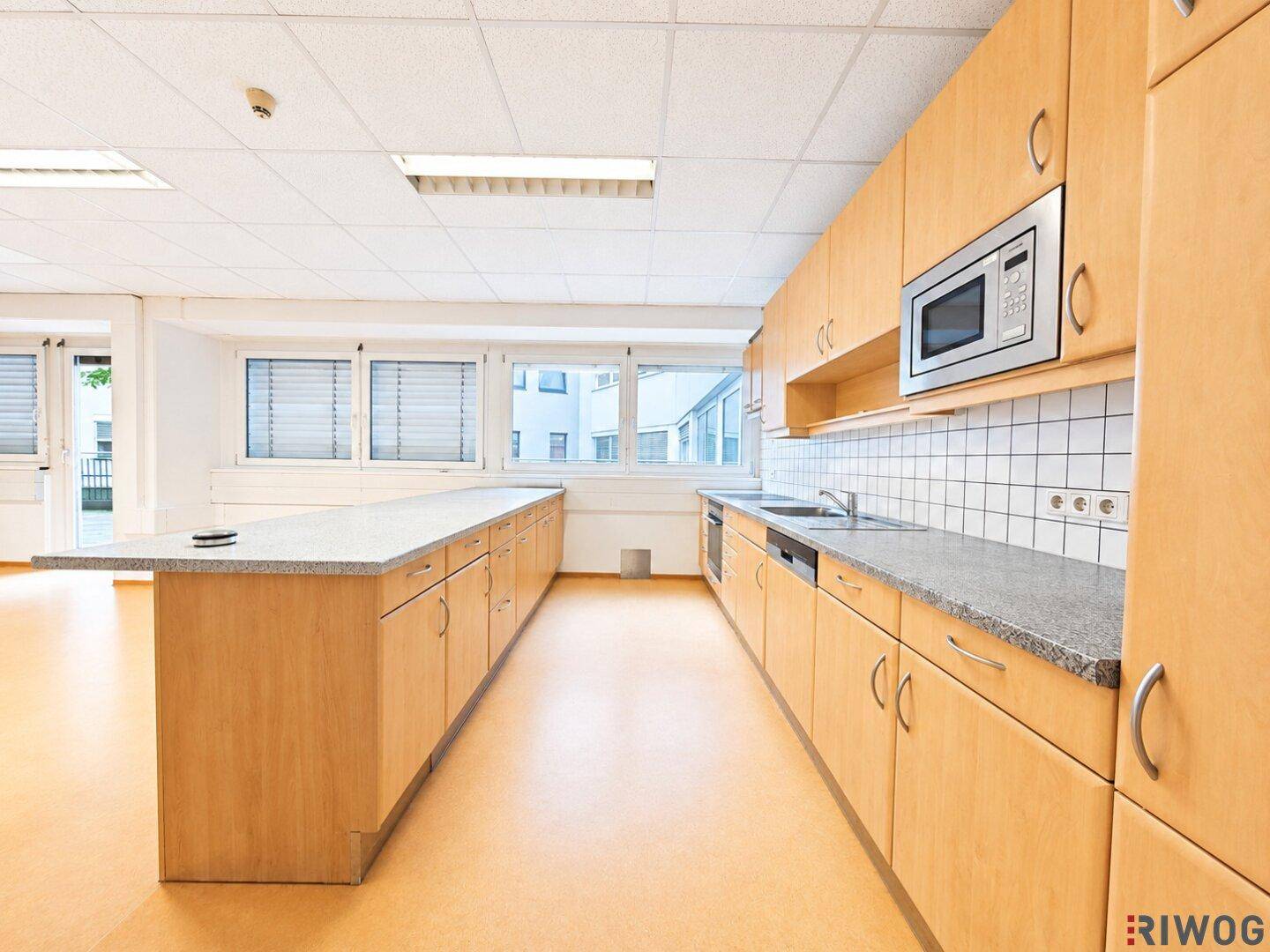 Funktionale Holzküche mit Granitarbeitsplatten, integrierter Mikrowelle und Fliesenrückwand.