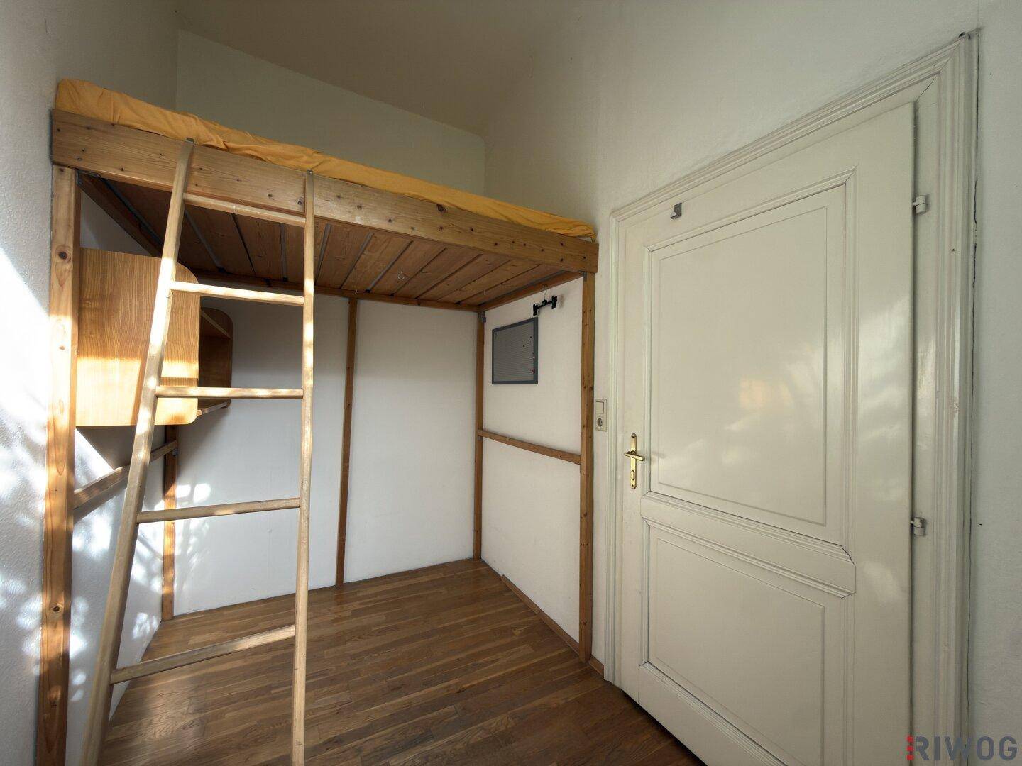 Schlafzimmer mit einem Hochbett aus Holz und Holzboden, ideal für platzsparendes Wohnen.