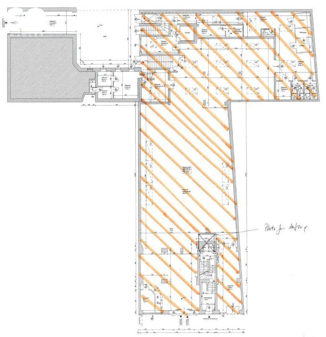 Grundrissplan eines großen Gewerberaums mit verschiedenen Bereichen und Treppenhaus.
