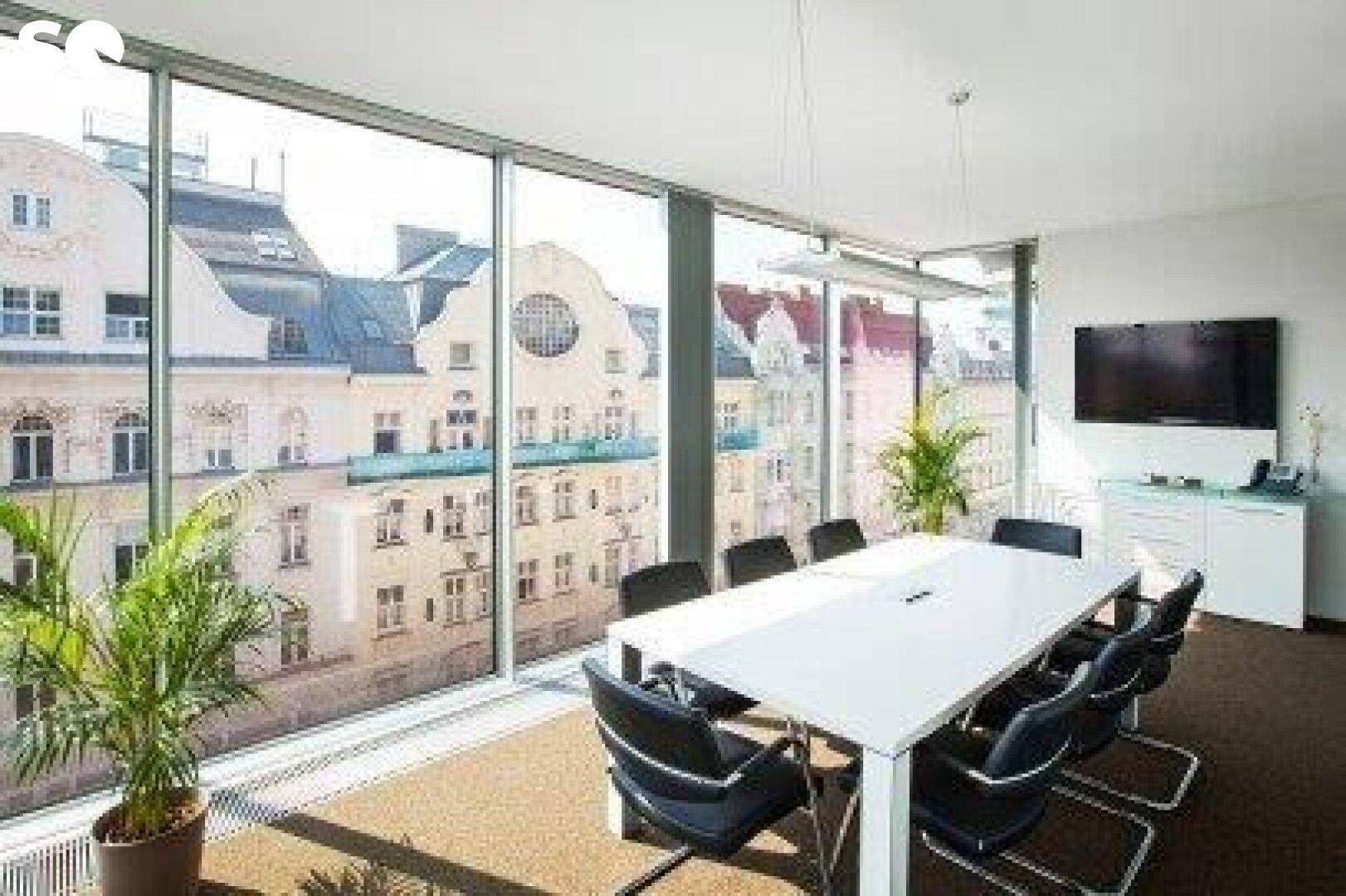 Moderner Konferenzraum mit großem Tisch, Stühlen und weitem Stadtblick durch die Panoramafenster.