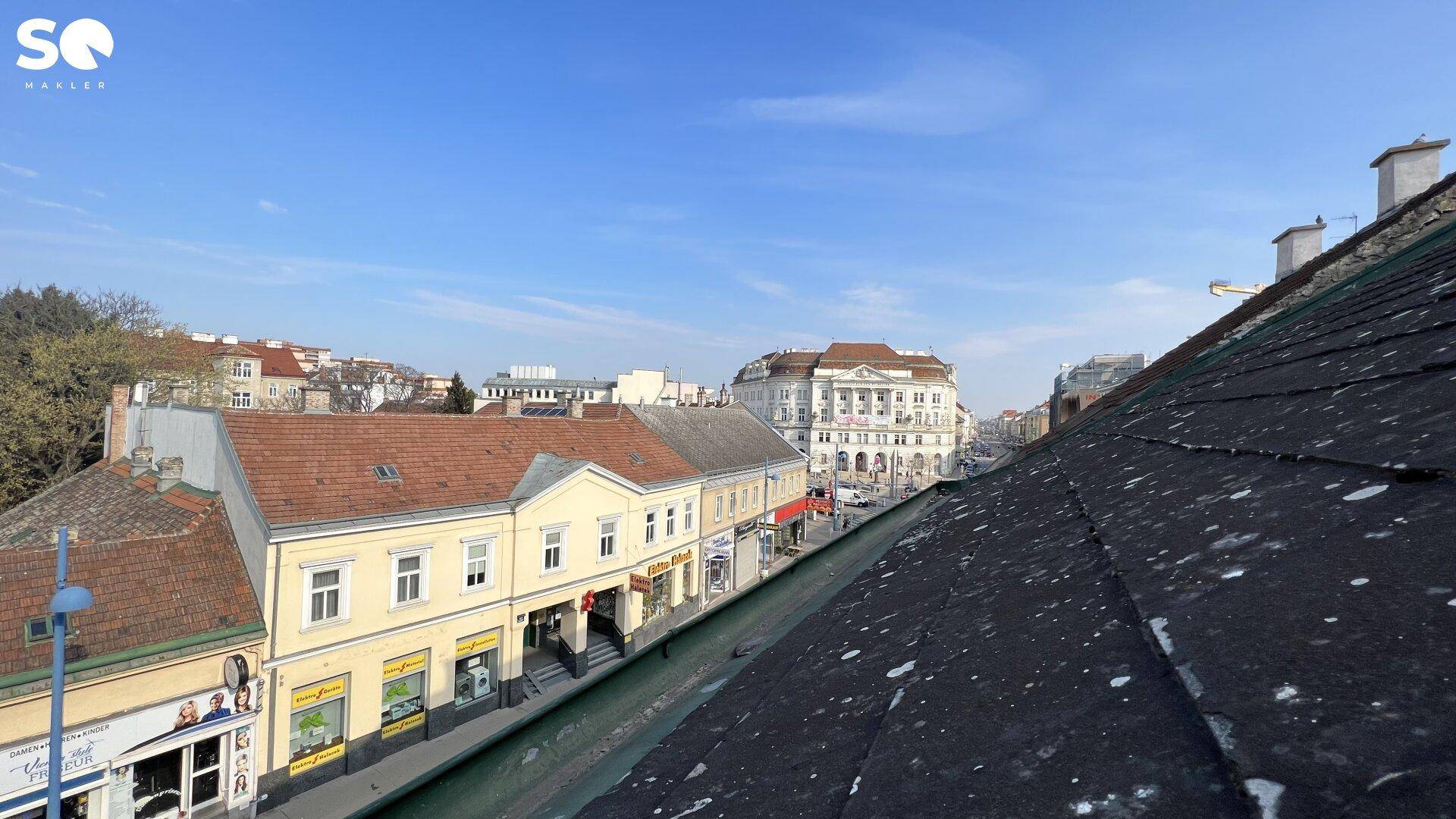 Blick über die Dächer der Stadt mit angrenzenden Gebäuden und einer belebten Straße.