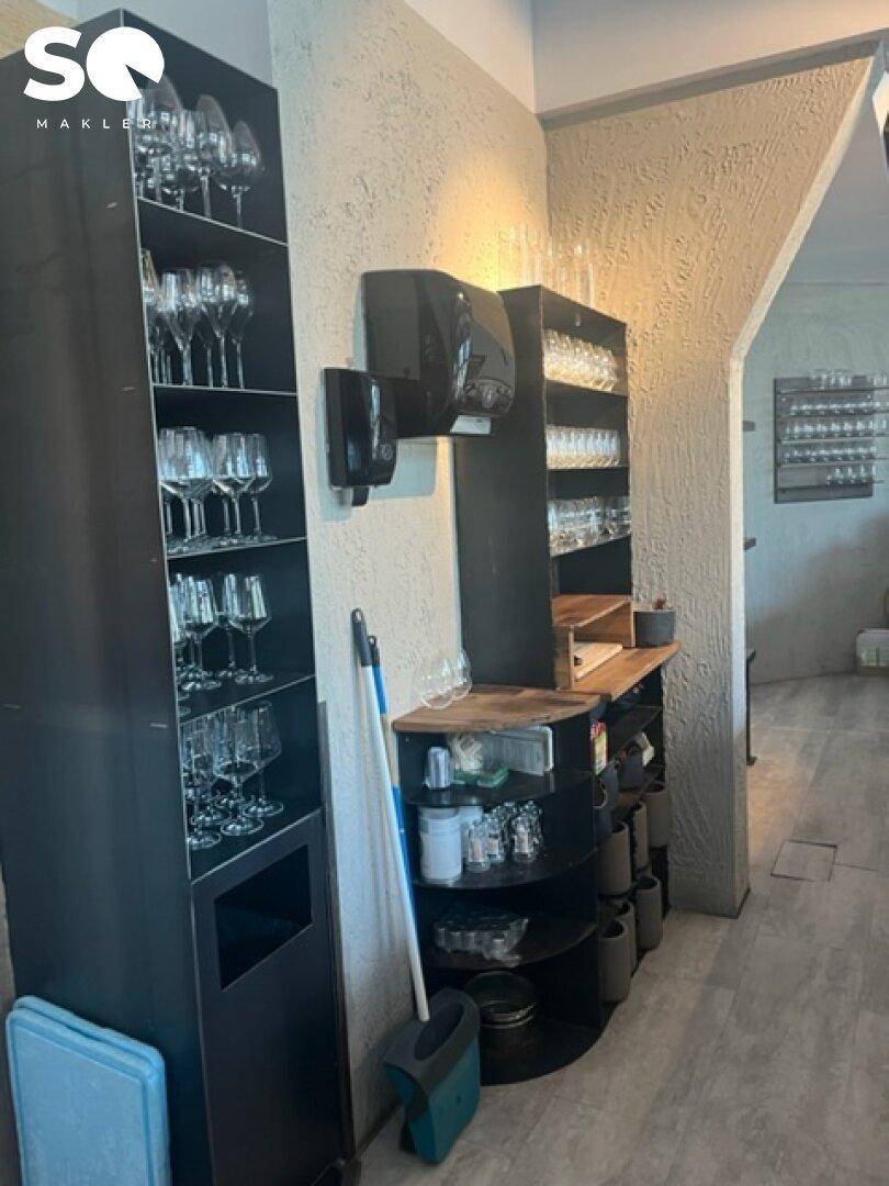 Lagerbereich mit Regalen voller Gläser und Reinigungsutensilien, gut organisiert.