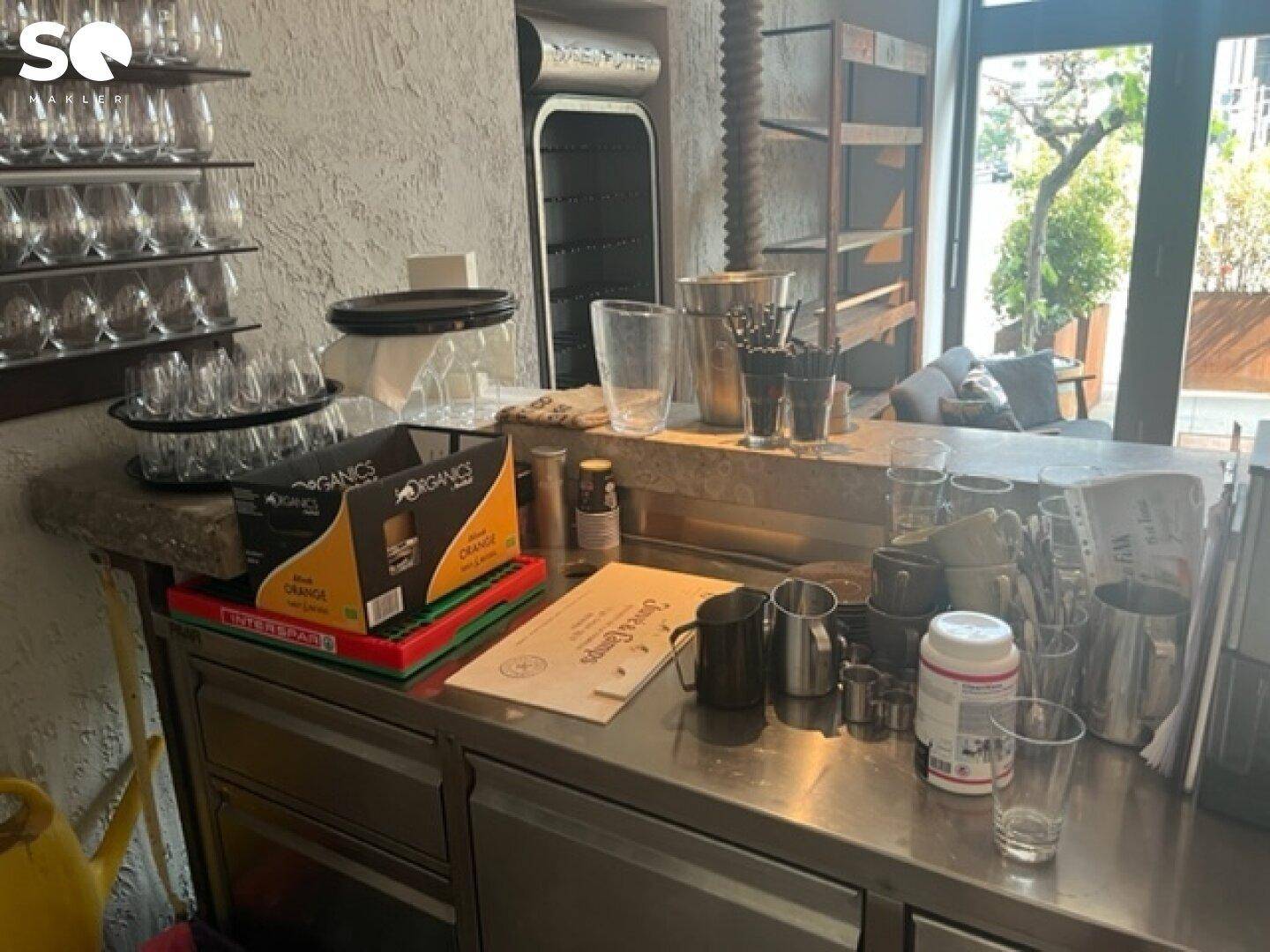 Thekenservicebereich mit Gläsern, Kaffeemaschine und verschiedenen Utensilien für den Gastronomiebetrieb.