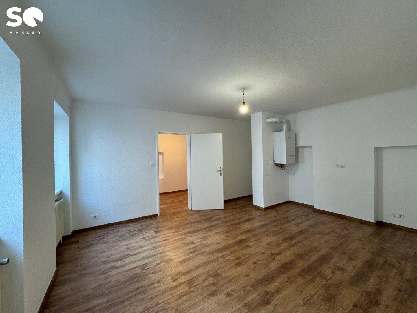 Geräumiges Zimmer mit Laminatboden und Heizungsanlage, ideal für flexible Nutzung.
