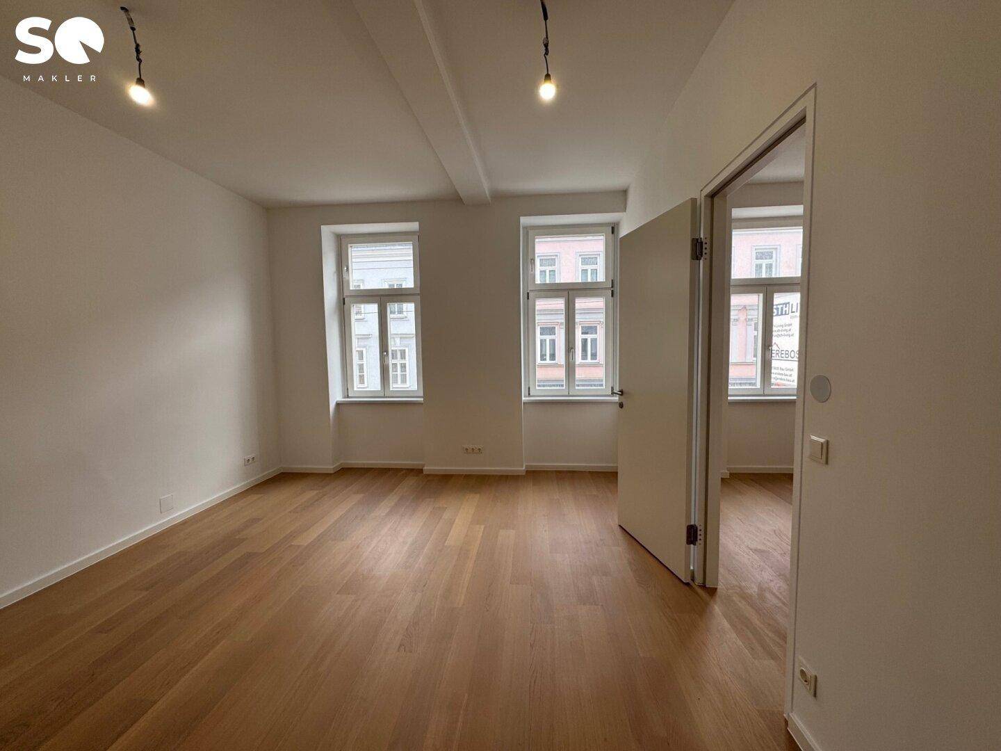 Lichtdurchfluteter Raum mit Parkettboden und hohen Decken, ideal für individuelle Gestaltung.