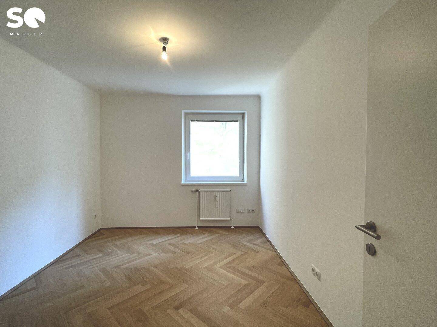 Kleineres Zimmer mit Fischgrätparkett und Fenster, ideal als Kinder- oder Arbeitszimmer.