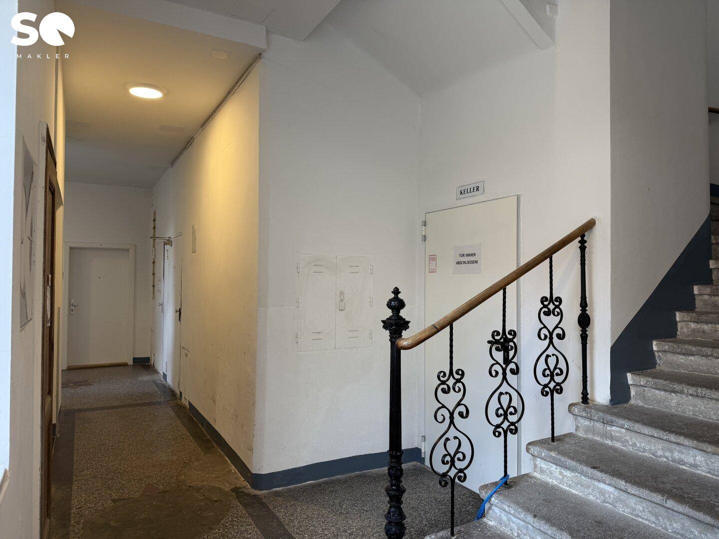 Treppenhaus und Gemeinschaftsbereich in einem Altbau mit Zugang zum Keller.