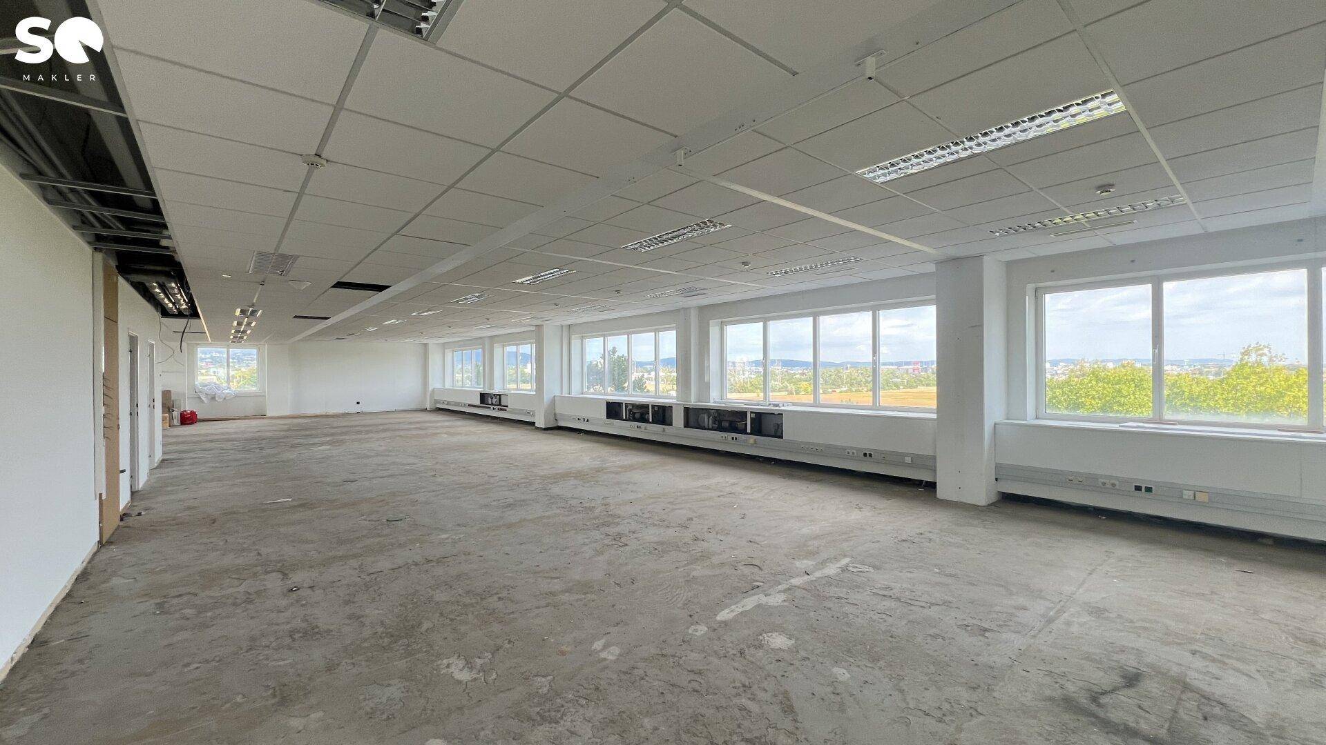 Geräumiges Büro mit vielen Fenstern, die viel Tageslicht hereinlassen und eine weite Aussicht bieten.