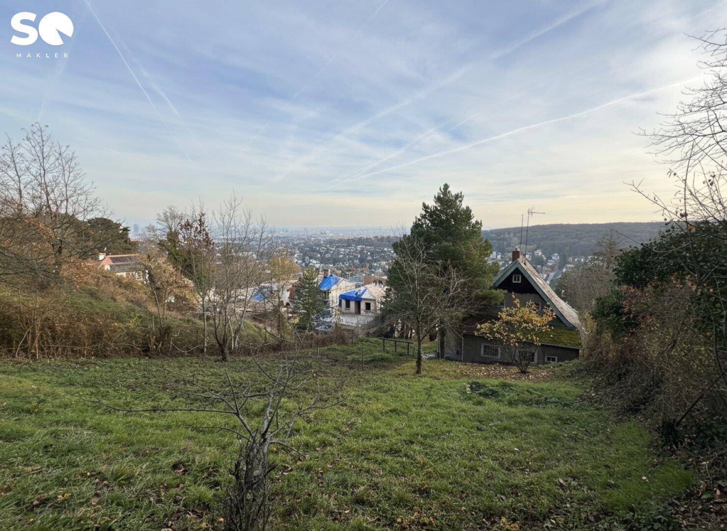 Weitläufiges Grundstück mit Blick auf die Stadt in der Ferne und umliegende Natur.