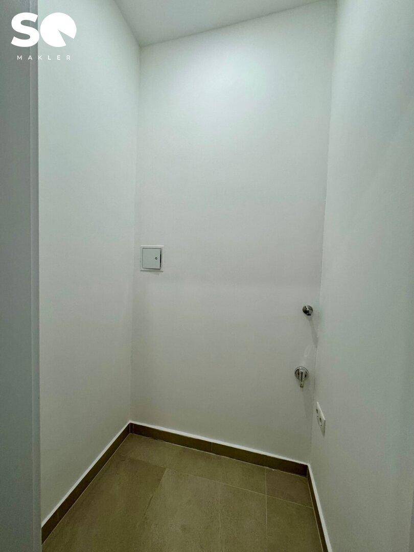 Kleiner Hauswirtschaftsraum mit Fliesenboden und Anschlüssen für Waschmaschine oder Trockner.