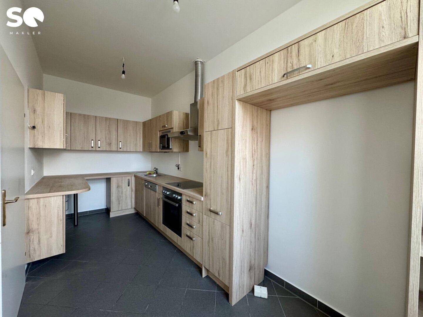 Moderne Einbauküche in Holzoptik mit integrierten Geräten und viel Stauraum.