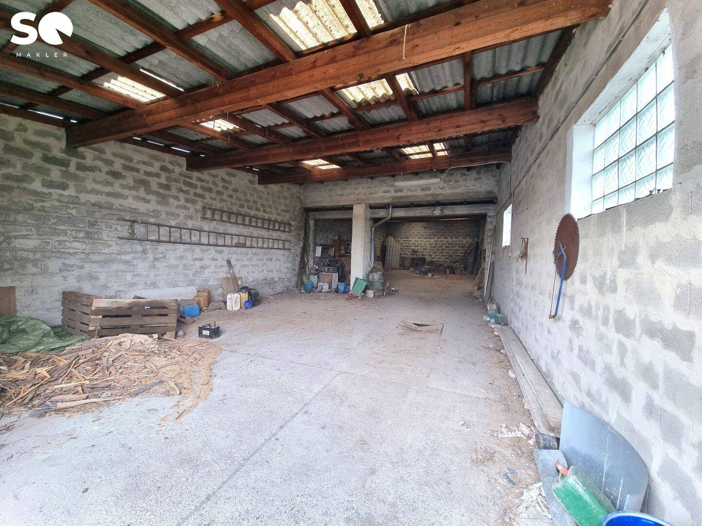 Große Scheune oder Lagerhalle mit Ziegelwänden, Holzdachkonstruktion und Oberlichtern.