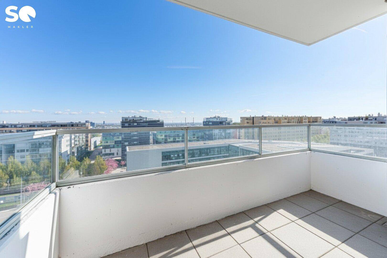 Geräumiger Balkon mit Glasgeländer und weitem Blick über die Stadt und die Umgebung.