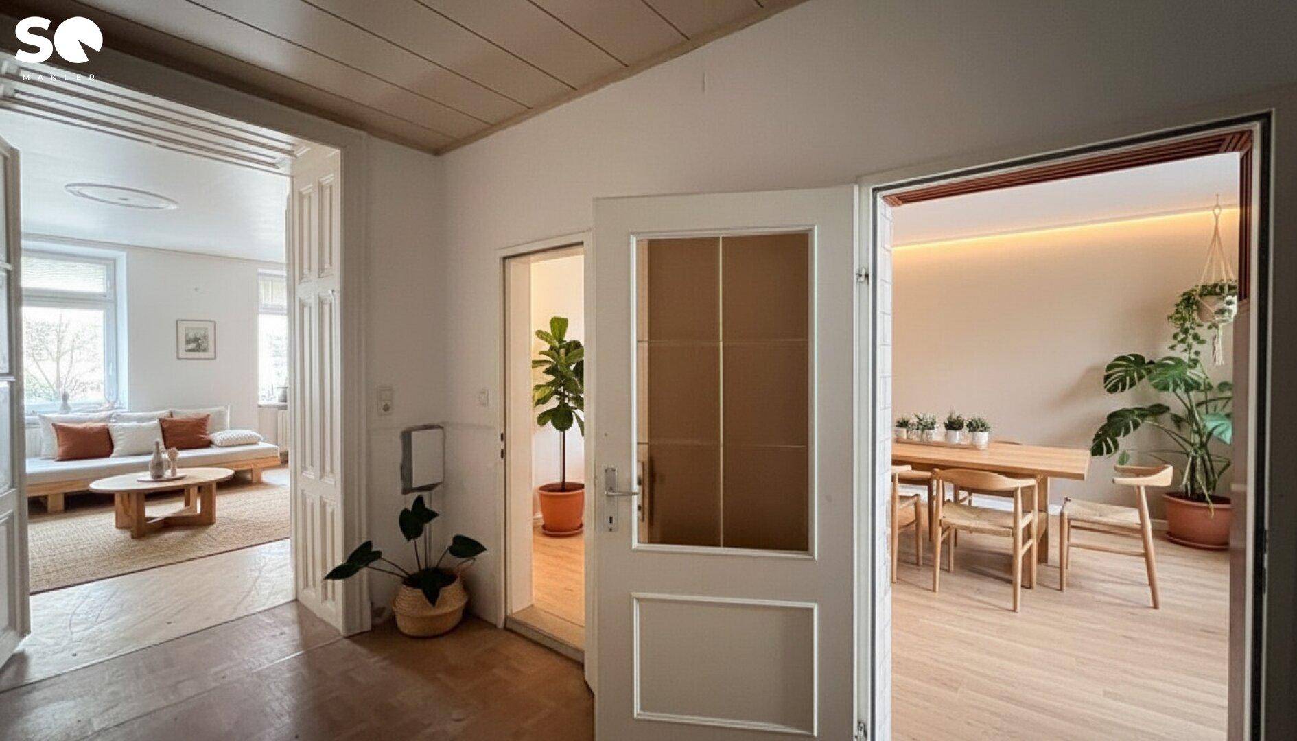 Heller Flur mit Zugang zu einem modern eingerichteten Wohnzimmer und einem Essbereich.