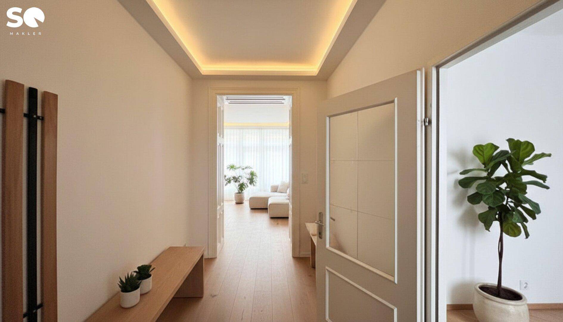 Modernisierter Flur mit indirekter Beleuchtung, Holzbänken und Pflanzen, der zu einem hellen Wohnbereich führt.