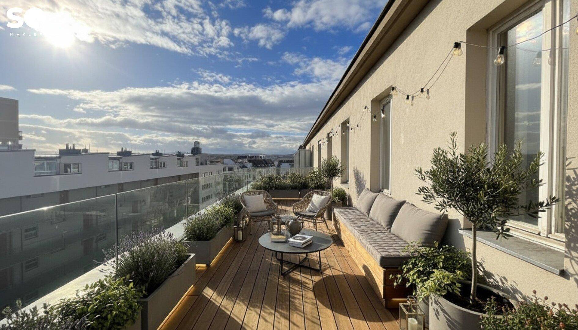 Renovierter Balkon mit Holzdeck, Pflanzen und gemütlicher Sitzecke.