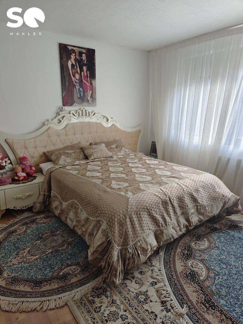 Hauptschlafzimmer mit großem Bett, opulentem Kopfteil und gemusterten Teppichen.