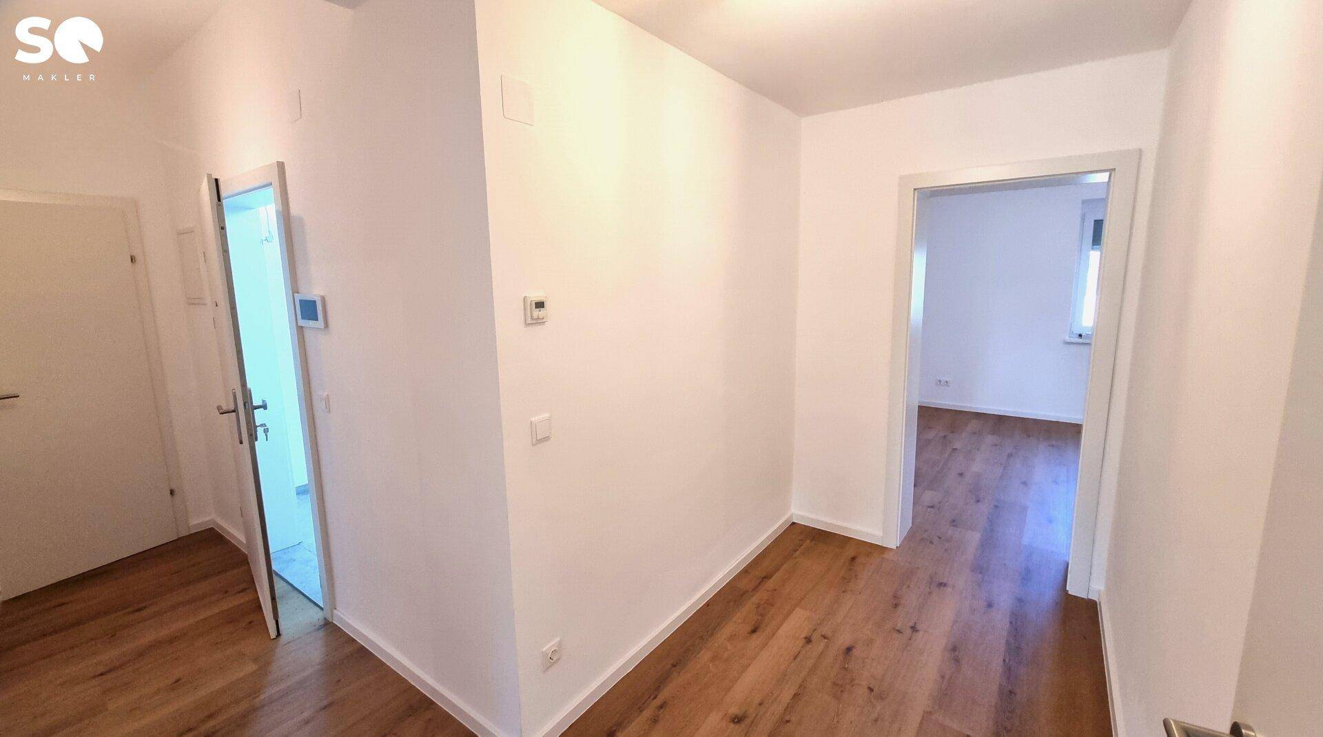 Geräumiger Flur mit Laminatboden und Zugang zu mehreren Zimmern.