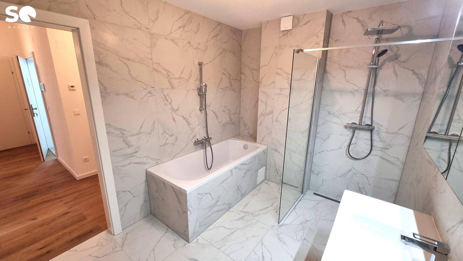 Modernes Badezimmer mit Badewanne, ebenerdiger Dusche und Waschtisch.