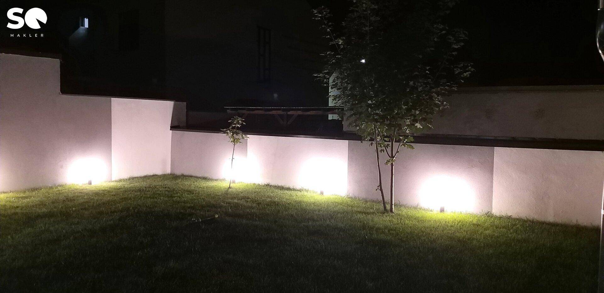Beleuchtete Rasenfläche im Garten bei Nacht, stimmungsvoll inszeniert durch Bodenleuchten.