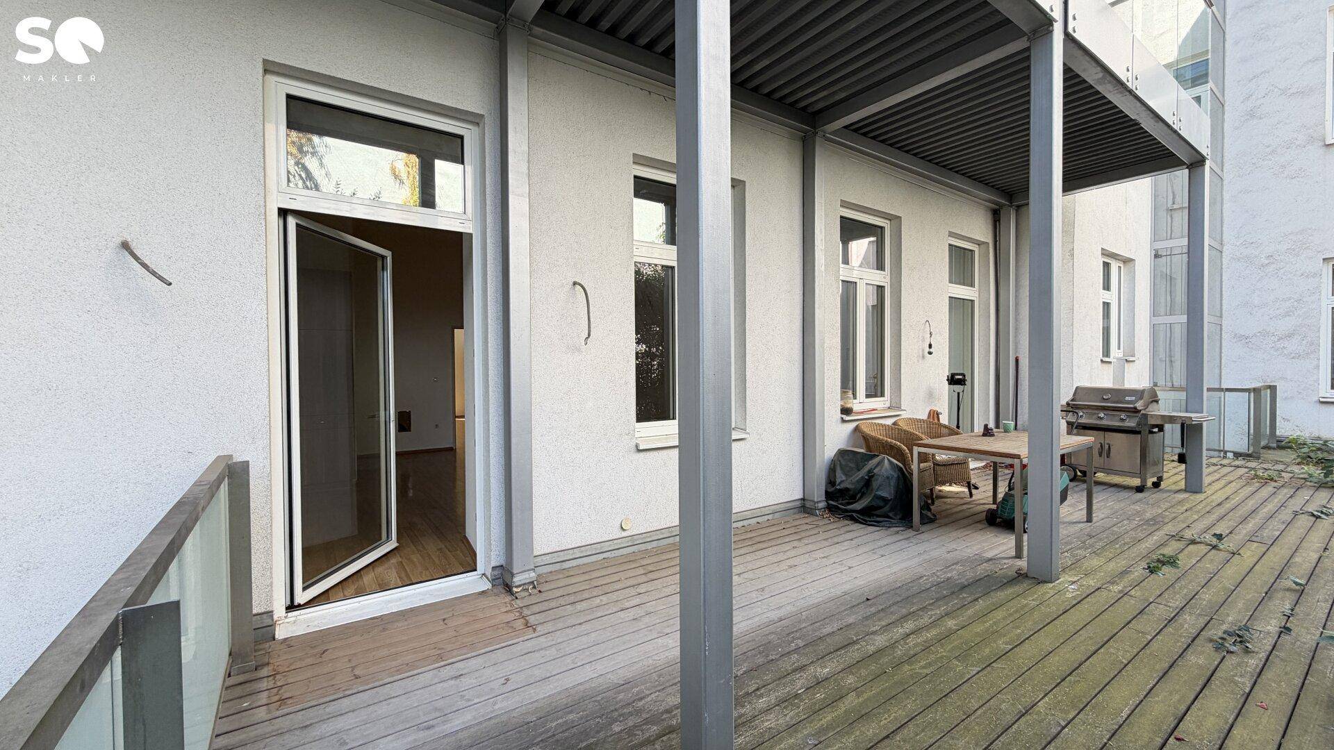 Große Holzterrasse mit Grillbereich und Sitzgelegenheiten für gesellige Stunden im Freien.