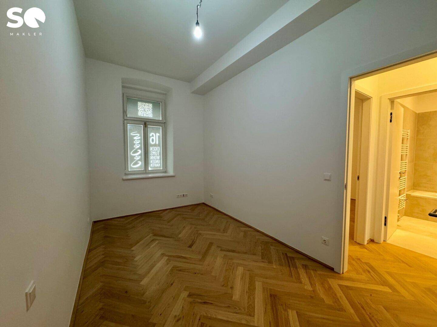 Gemütliches Zimmer mit Fischgrätparkett und einem Fenster, ideal als Schlaf- oder Arbeitszimmer.
