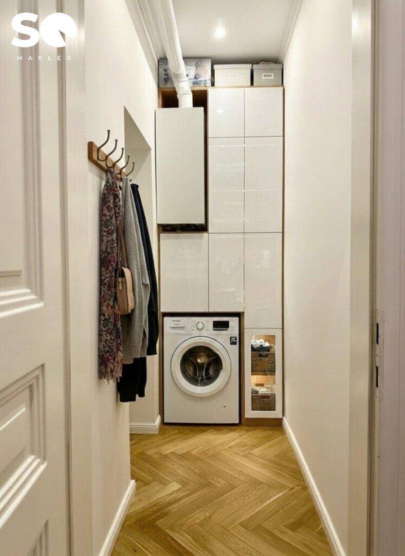 Praktischer Hauswirtschaftsraum mit Waschmaschine und integrierten Schränken.