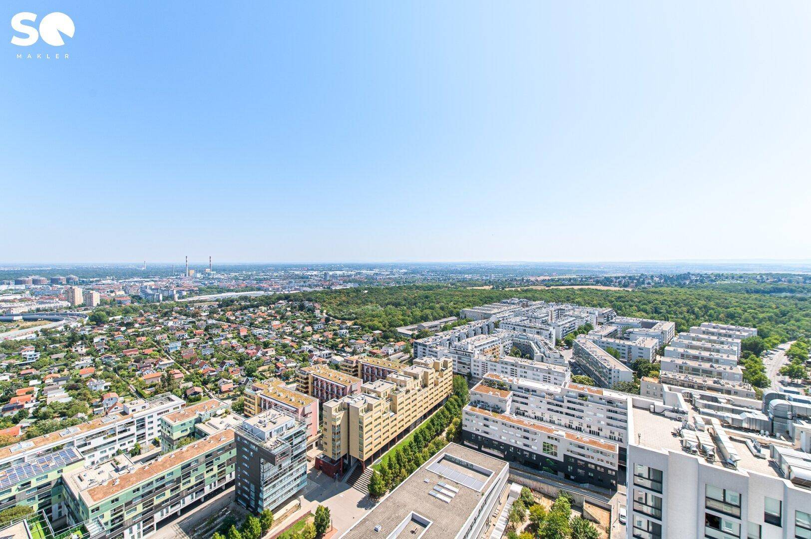 Weitläufiger Panoramablick über die Stadt mit vielen Gebäuden und grünen Erholungsflächen.