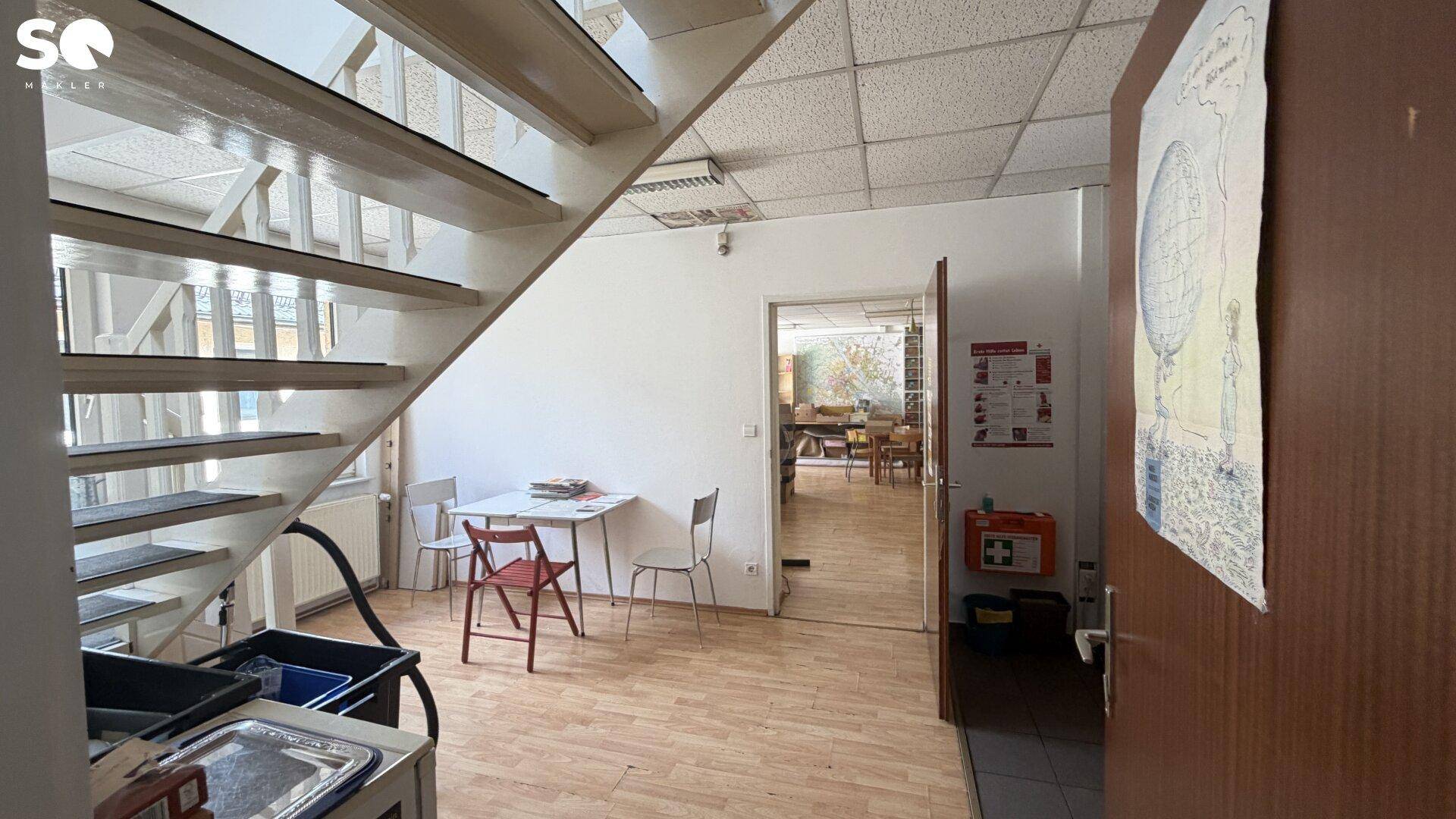 Eingangsbereich mit Treppe, kleinem Tisch und Zugang zu weiteren Räumen.