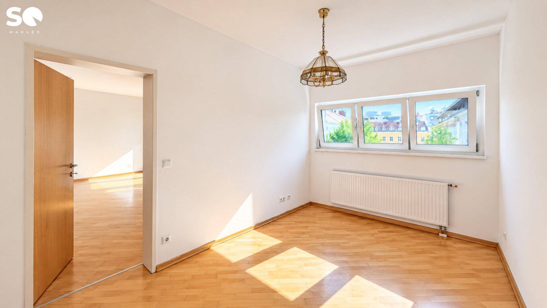 Schlafzimmer mit Parkettboden, großen Fenstern und viel Tageslicht.