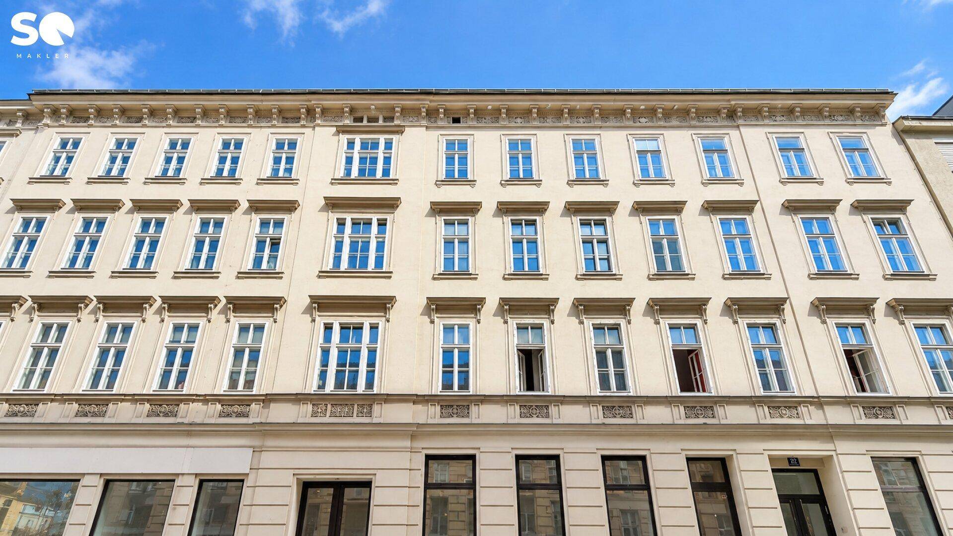 Detailansicht der historischen Fassade eines Gebäudes mit zahlreichen Fenstern und Verzierungen.