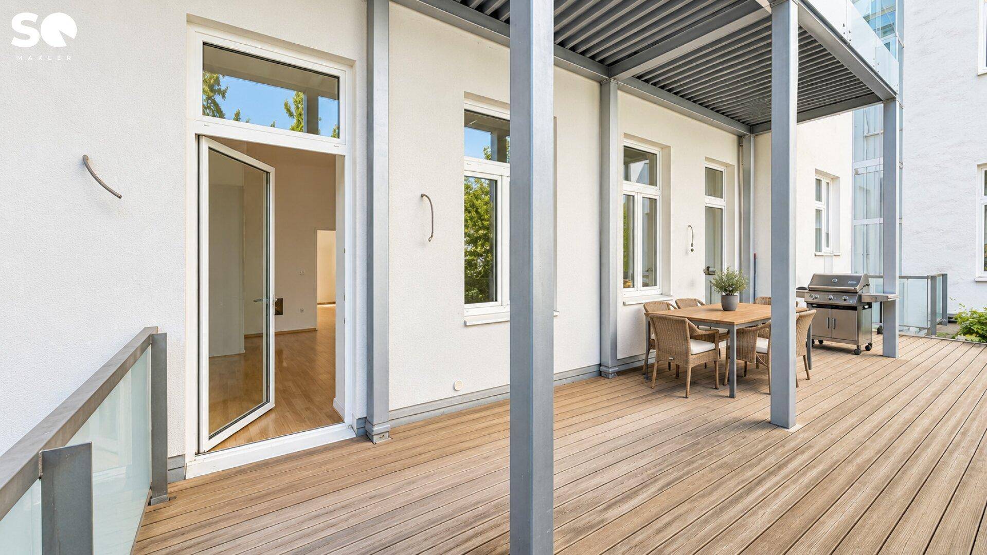 Große Holzterrasse mit Esstisch und Grillbereich, perfekt für entspannte Stunden im Freien.