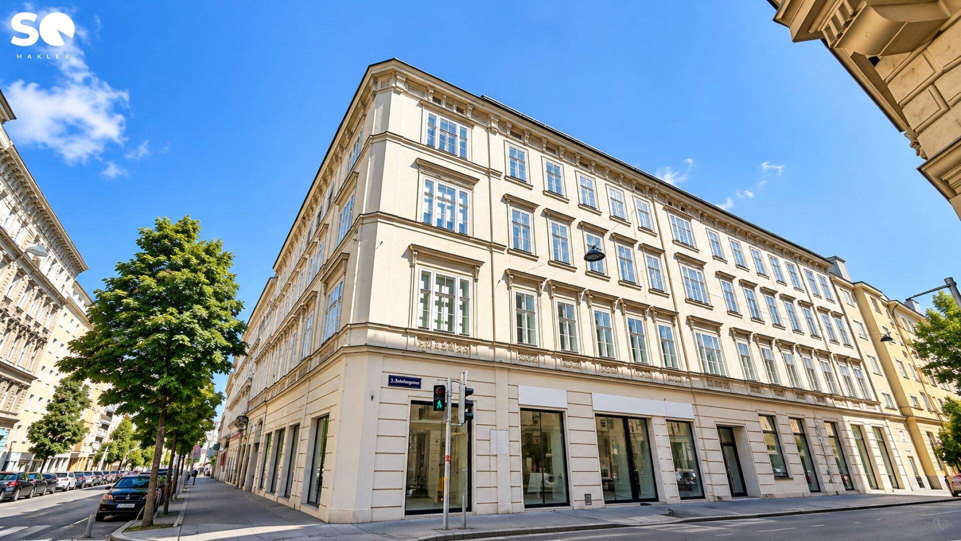Elegantes Eckgebäude mit klassischer Architektur und vielen Fenstern an einer städtischen Straße.