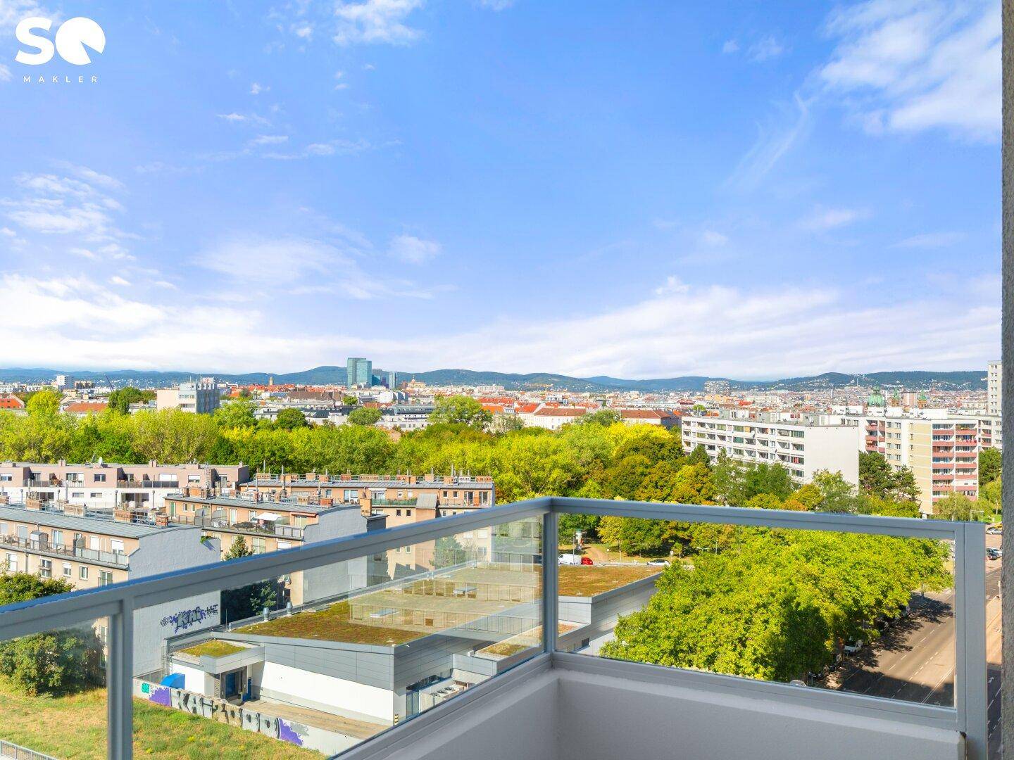 Balkon mit Panoramablick über die Stadt und die umliegende grüne Landschaft.