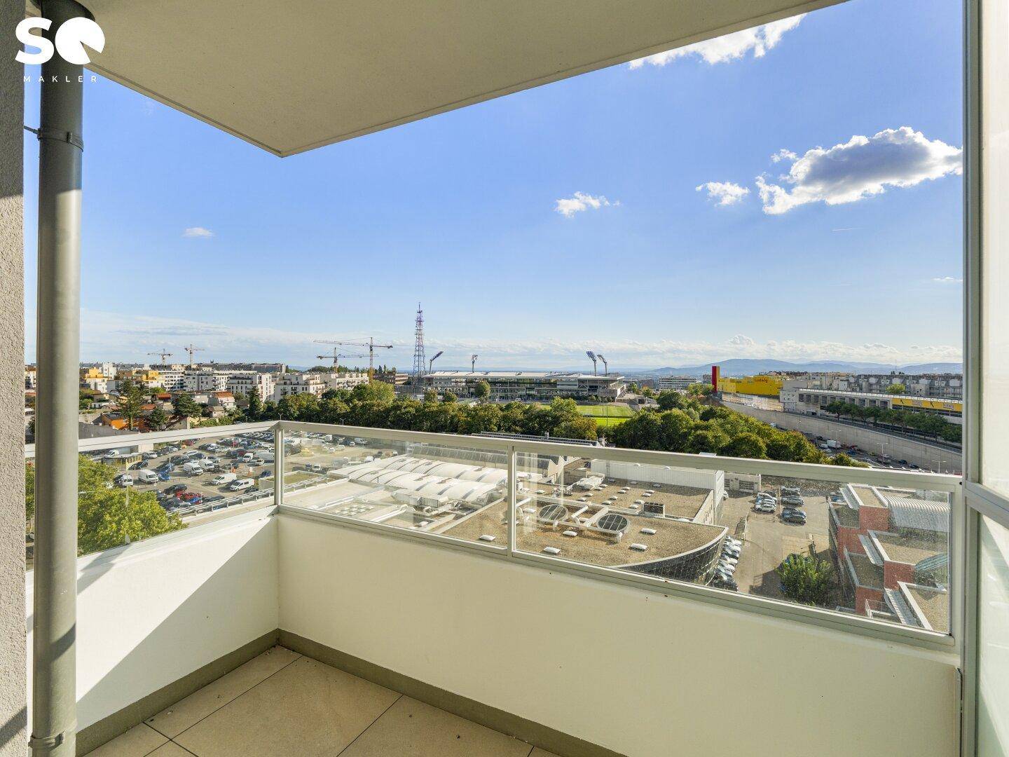Balkon mit Glasbrüstung und weitem Blick über die Stadt und die Umgebung.