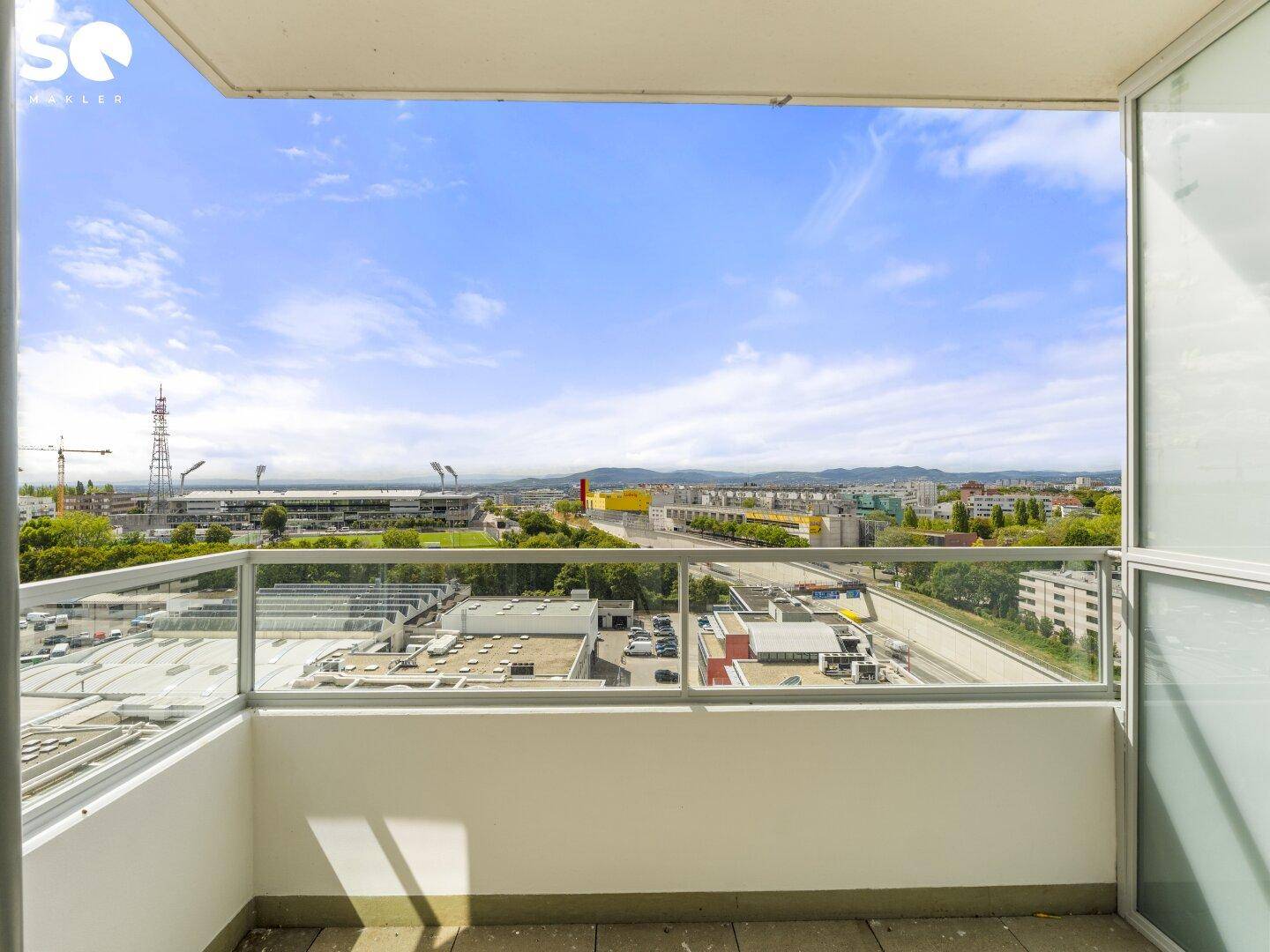 Geräumiger Balkon mit Glasbrüstung und weitem Blick über die Stadt und Umgebung.