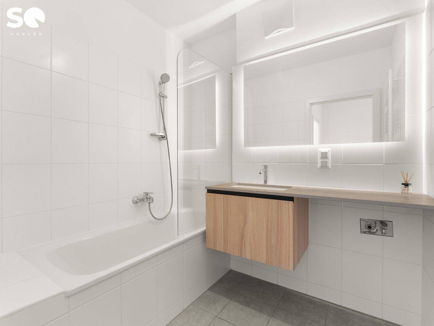 Modernes Badezimmer mit Badewanne, Waschtisch und beleuchtetem Spiegel.