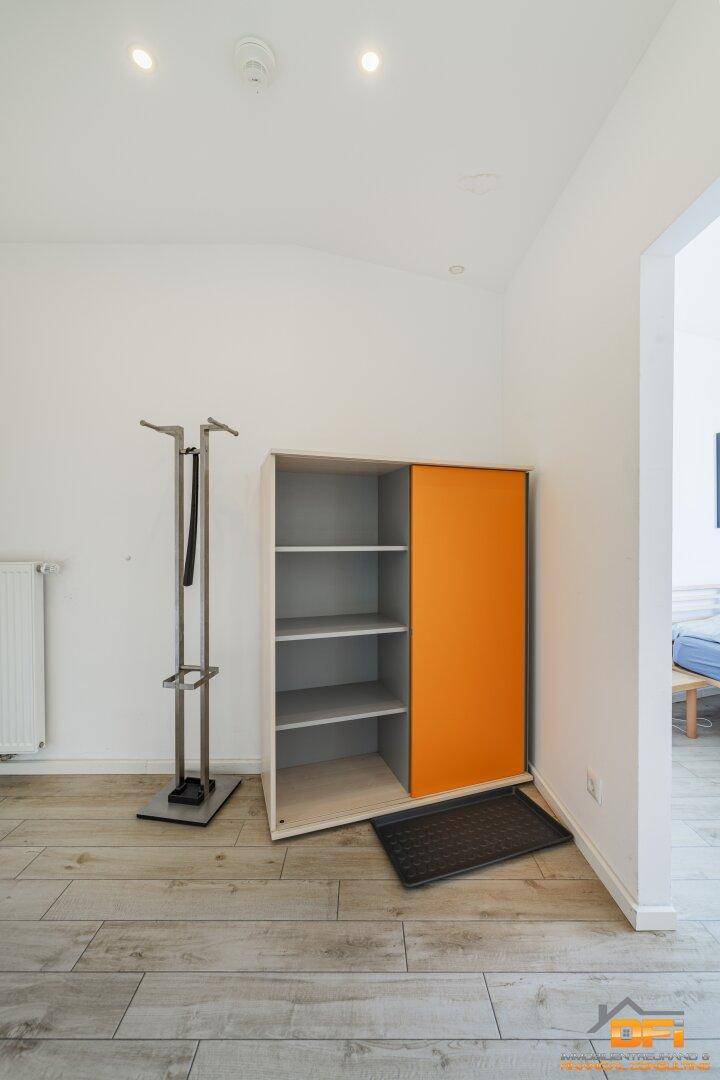 Eingangsbereich mit praktischem Schuhschrank in Weiß und Orange sowie einer modernen Garderobe.