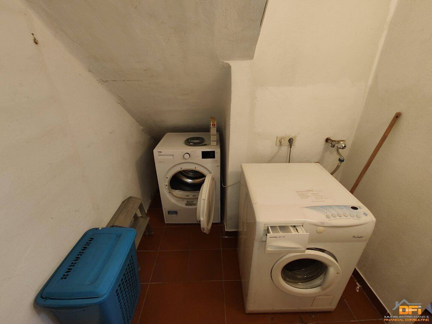 Hauswirtschaftsraum mit Waschmaschine und Trockner unter einer Dachschräge.