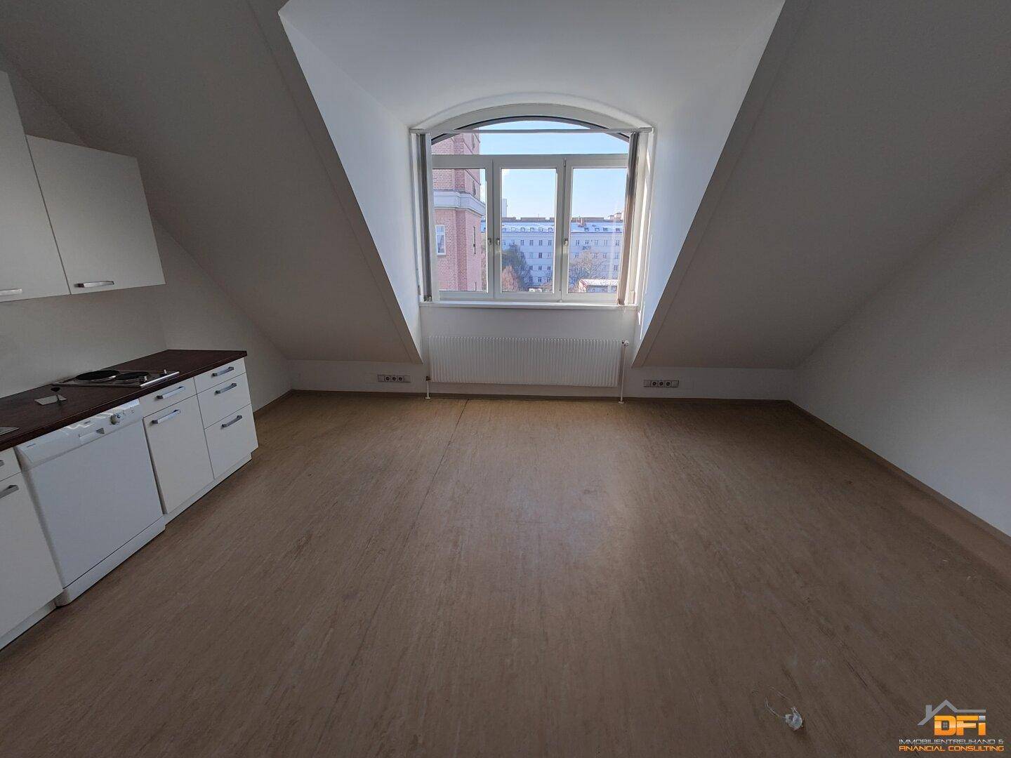 Küchenbereich mit großem Bogenfenster, das viel Tageslicht hereinlässt und Stadtblick bietet.